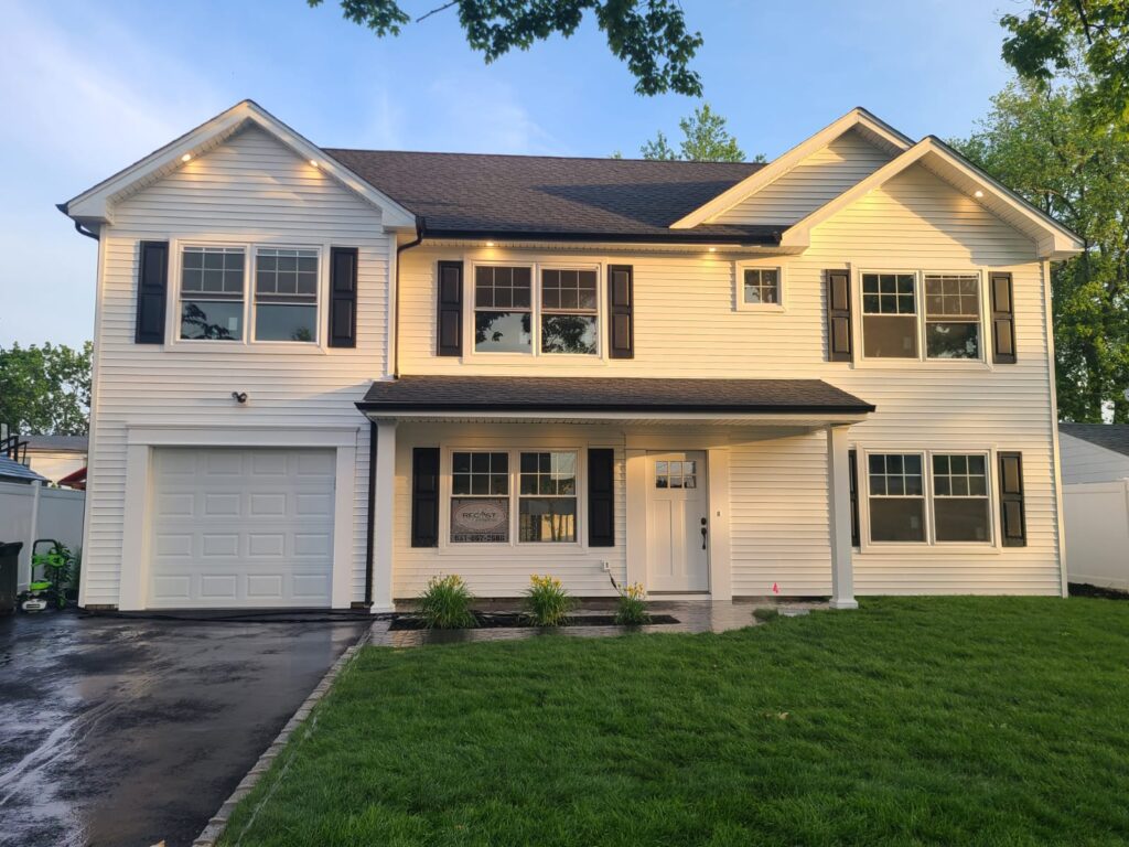 replacement windows long beach installed on a beige two-story home with white trim and double-hung windows