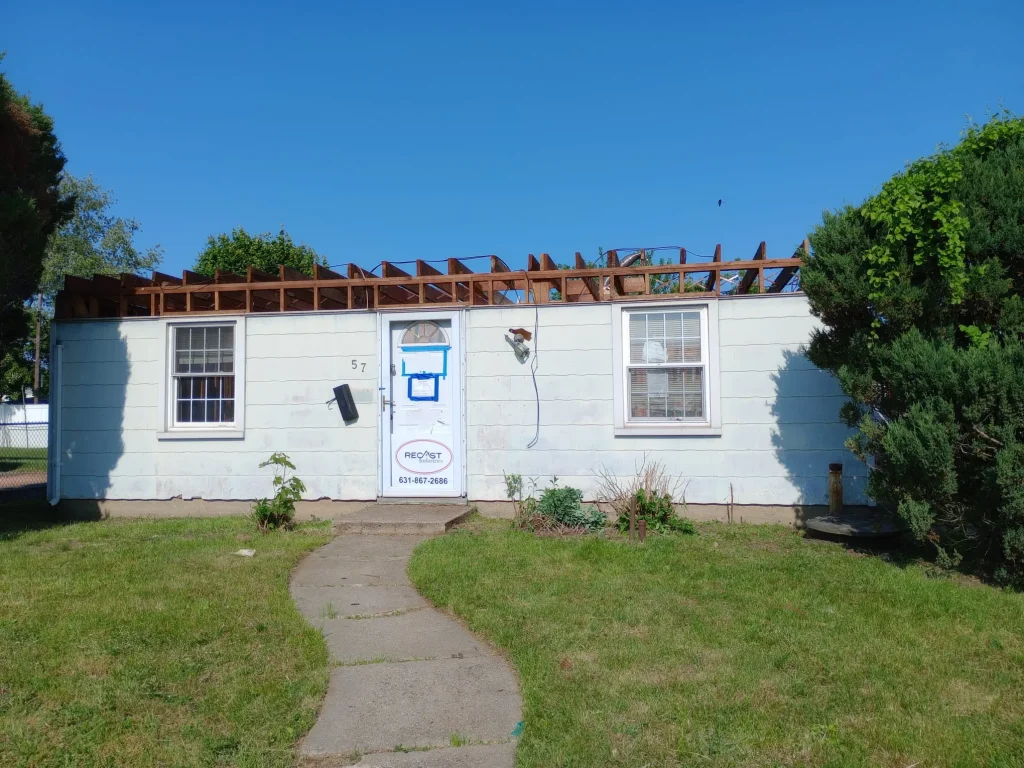 Rustic wood siding home in Long Beach Island NY with metal roofing in a snowy setting